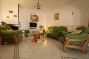 een woonkamer met twee groene banken en een televisie bij VILLA TIMEA in Castrignano del Capo