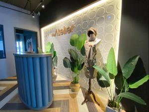 uma sala com plantas, um manequim e uma parede em The Atelier Boutique Hotel em Kota Kinabalu