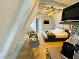 a small room with a bed and a desk with a table at Sarlat.Catalina in Sarlat-la-Canéda +103 photos