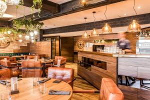 a man standing at a bar in a restaurant at Samantta Hotel & Restaurant in Haukipudas