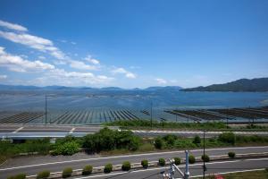 a road next to a large body of water at Global Resort Miyajima View in Hatsukaichi