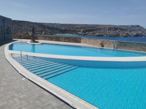 a large swimming pool with blue water at Paradise Bay Resort in Mellieħa