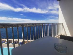a table on a balcony with a view of the ocean at Paradise Bay Resort in Mellieħa