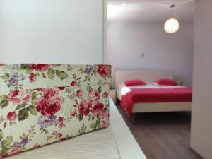 奧米什的住宿－Apartment Bajama，一间卧室配有一张床和一张鲜花沙发