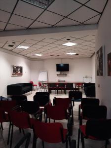 a room with chairs and a table and a tv at Hotel Rossi in San Marino