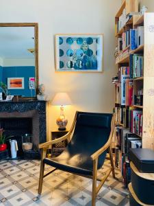 a chair in a living room with bookshelves at La maison Gerval in Bédoin