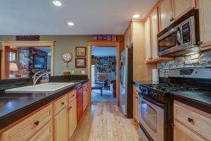 una cocina con fregadero y estufa en Wanderlust with Rustic Stone Fireplace, en Hood River