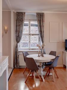 a dining room with a table and chairs and a window at Altstadtjuwel in Meißen