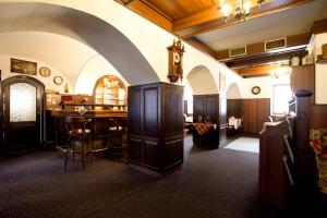 una habitación con una mesa y un reloj en la pared en Hotel U Jiřího en Humpolec