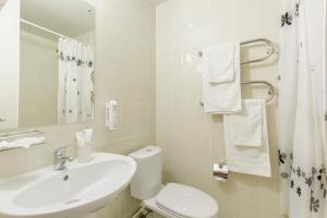 ein Badezimmer mit einem weißen WC und einem Waschbecken in der Unterkunft Hotel Avrora in Omsk