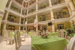 une salle à manger avec des tables vertes et des chaises blanches dans l'établissement Villa las Margaritas Plaza Cristal, à Xalapa
