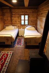 a room with two beds in a wooden cabin at Збориште in Brdo