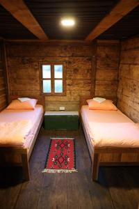 a room with two beds in a wooden cabin at Збориште in Brdo