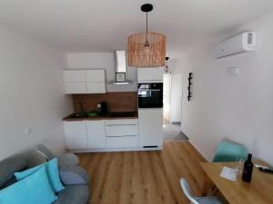 een woonkamer met een bank en een keuken bij Zum Hofgassl Haus Isi in Mörbisch am See