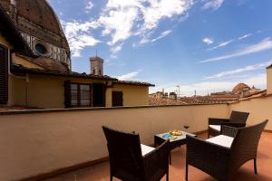 a patio with chairs and a table on a roof at Era Rental Apartments in Florence