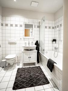 a bathroom with a sink and a tub and a toilet at Altstadtjuwel in Meißen