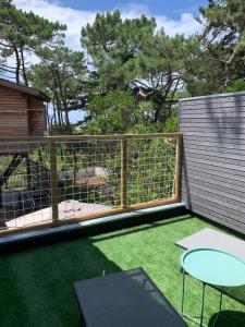 un chien dans une cage sur un pont avec de l'herbe dans l'établissement LE CHALET DE L'OCÉAN, à Lacanau-Océan 6 autres photos