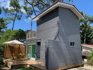 une maison modulaire avec une terrasse et un toit dans l'établissement LE CHALET DE L'OCÉAN, à Lacanau-Océan