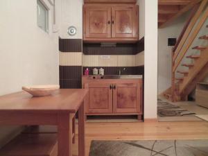 cocina con armarios de madera y mesa de madera en Our House Apartments en Kolašin