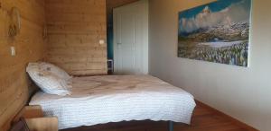 uma cama num quarto com uma fotografia na parede em Chambre d'hôtes à la ferme em Beaune