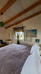 a bedroom with a large bed with a window at Momentum Θ in Maleme +178 photos