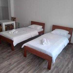 duas camas com lençóis brancos num quarto em Guest house Erdan em Plav