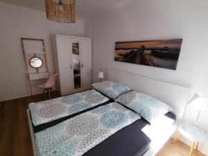 1 dormitorio con 1 cama y una pintura en la pared en Zum Hofgassl Haus Flo en Mörbisch am See