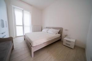 Habitación blanca con cama y ventana en Beat House&Apartments, en Agrate Brianza