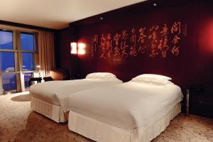 two beds in a hotel room with writing on the wall at Grand Hyatt Shanghai in Shanghai