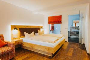 ein Schlafzimmer mit einem Bett und einem Sofa in der Unterkunft Hotel Tannenmühle in Grafenhausen