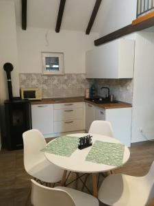 a kitchen with a white table and white chairs at Holiday Home Nektar Park in Bihać