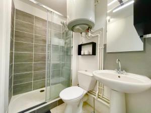 La salle de bains est pourvue de toilettes, d'un lavabo et d'une douche. dans l'établissement L'ESCALE - 300 m Océan - Hyper Centre - Lumineux - Garage Privatif, à Saint-Nazaire