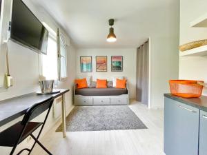 - un petit salon avec un canapé et des oreillers orange dans l'établissement L'ESCALE - 300 m Océan - Hyper Centre - Lumineux - Garage Privatif, à Saint-Nazaire