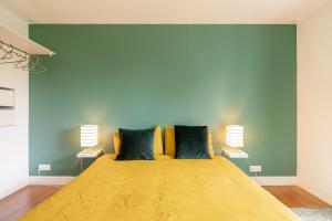 a bedroom with a large yellow bed with two lamps at Ecrin cosy au coeur de Thollon (Sauna !) in Thollon
