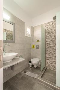 a bathroom with a sink and a toilet at Marianna Hotel in Perissa