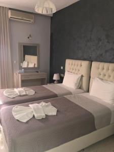 um quarto com uma cama grande e toalhas em Labyrinth Hotel em Georgioupolis