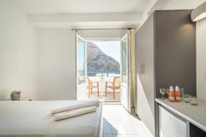 a bedroom with a bed and a view of the ocean at Marianna Hotel in Perissa
