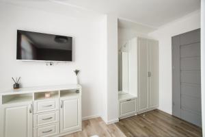 a white bathroom with a tv on the wall at Apart Hotel Fresh in Oradea