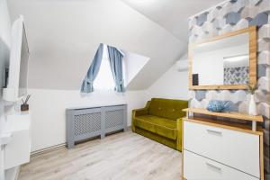 uma sala de estar com um sofá verde e um espelho em Apart Hotel Fresh em Oradea