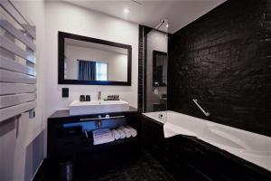 a bathroom with a sink and a tub and a mirror at YOOMA Urban Lodge in Brussels +47 photos