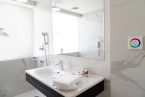 La salle de bains blanche est pourvue d'un lavabo et d'un miroir. dans l'établissement Blanca Hotel, à Izmir