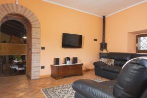 Casa di campagna في سبوليتو: غرفة معيشة مع أريكة وتلفزيون بشاشة مسطحة