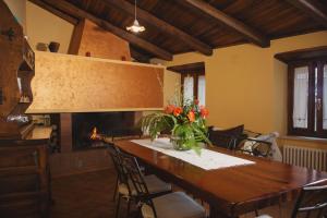 Casa di campagna في سبوليتو: غرفة طعام مع طاولة ومدفأة