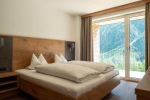 a bedroom with a large bed with a large window at Anraitl Appartements Sölden in Sölden
