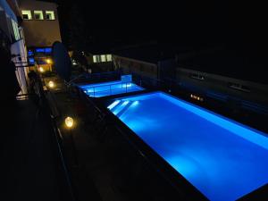 una gran piscina por la noche con iluminación azul en GWAREK Centrum Wypoczynkowe en Ustroń
