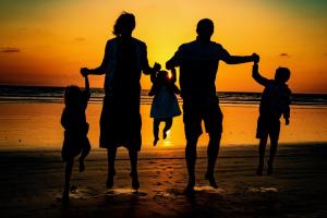 een gezinswandeling op het strand bij zonsondergang bij G218 - Palms Away in Oceanside