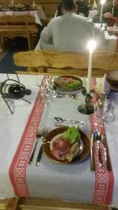 a table with a plate of food and a candle at Zrub Niki in Ždiar
