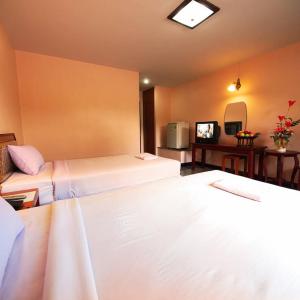 a hotel room with two beds and a television at โรงแรมเกียรตินคร (Kiatnakhon Hotel) in Nakhon Si Thammarat