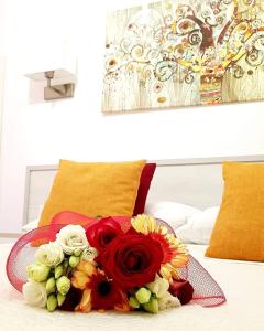 un mazzo di fiori seduto sopra un letto di Porta Terra Apartment a Cefalù