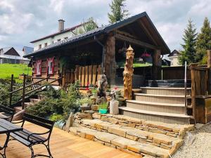 une maison avec un escalier en pierre en face d'une maison dans l'établissement Zrub Niki, à Ždiar